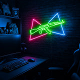 AK Split Triangles LED neon sign in the Original colorway, mounted on a brick wall in a gaming room