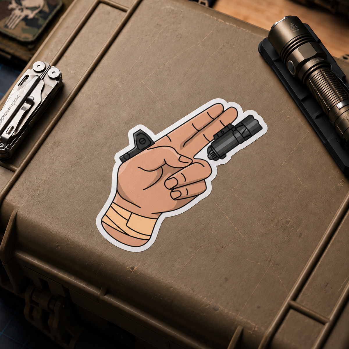 TacArt Finger Gun v6 vinyl sticker displayed on a tan equipment case
