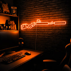 Suppressed Lever Gun LED neon sign in Orange on a clear backerboard in the TacArtCo gaming room